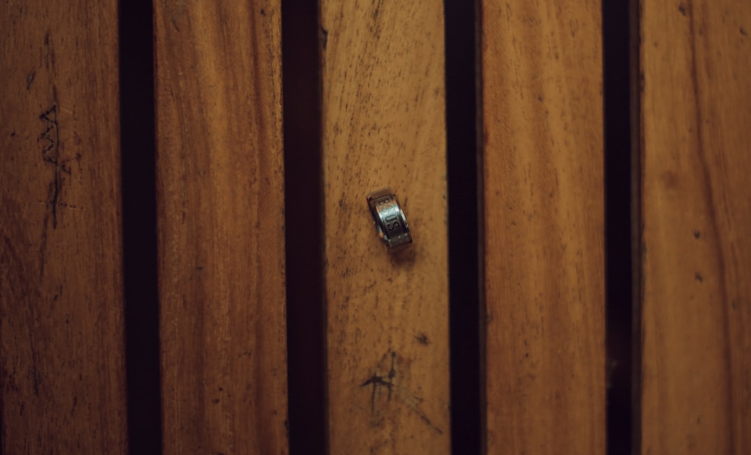 Open wardrobe door showing a European concealed cup hinge with adjustment screws and a Pozidriv screwdriver.